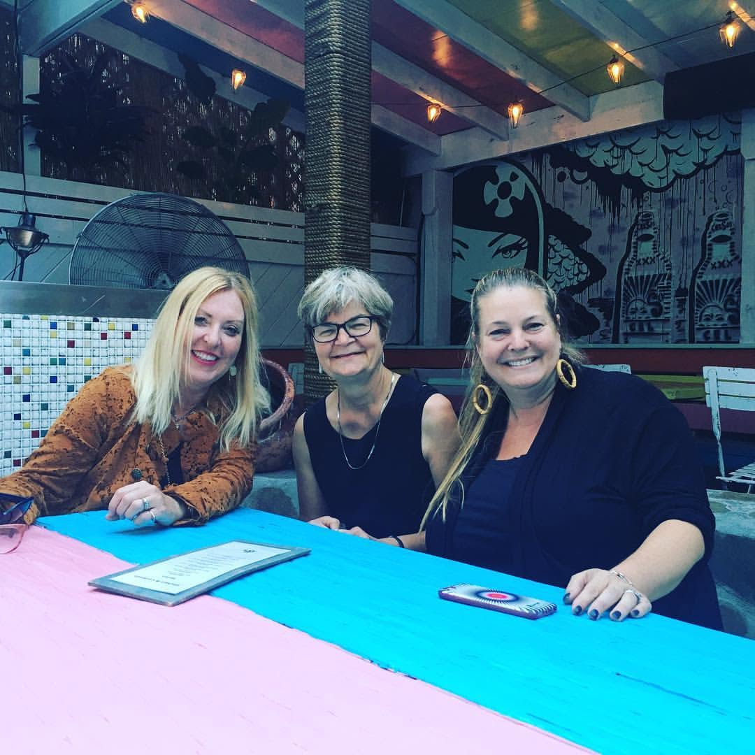 Lisa and friends smiling together at a colorful table